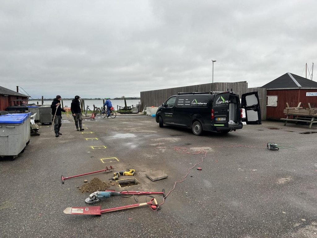 Opgravning og skæring af asfalt for at kunne nedgrave hegnspæle